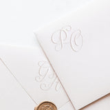 White envelopes with monogram embossed for wedding