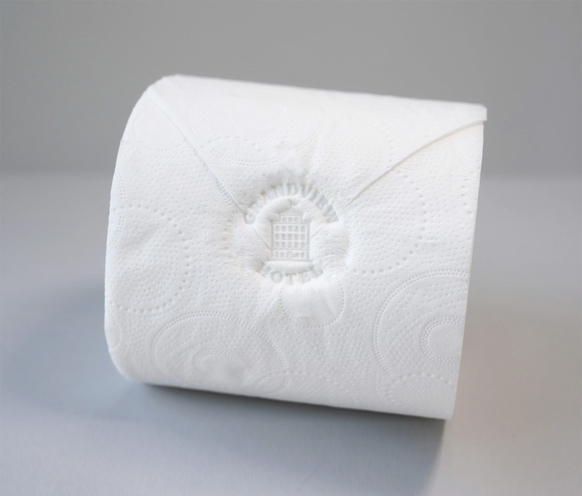Toilet roll featuring a custom detailed logo that has been pressed into the toilet roll with a pixie stamp or toilet roll stamp