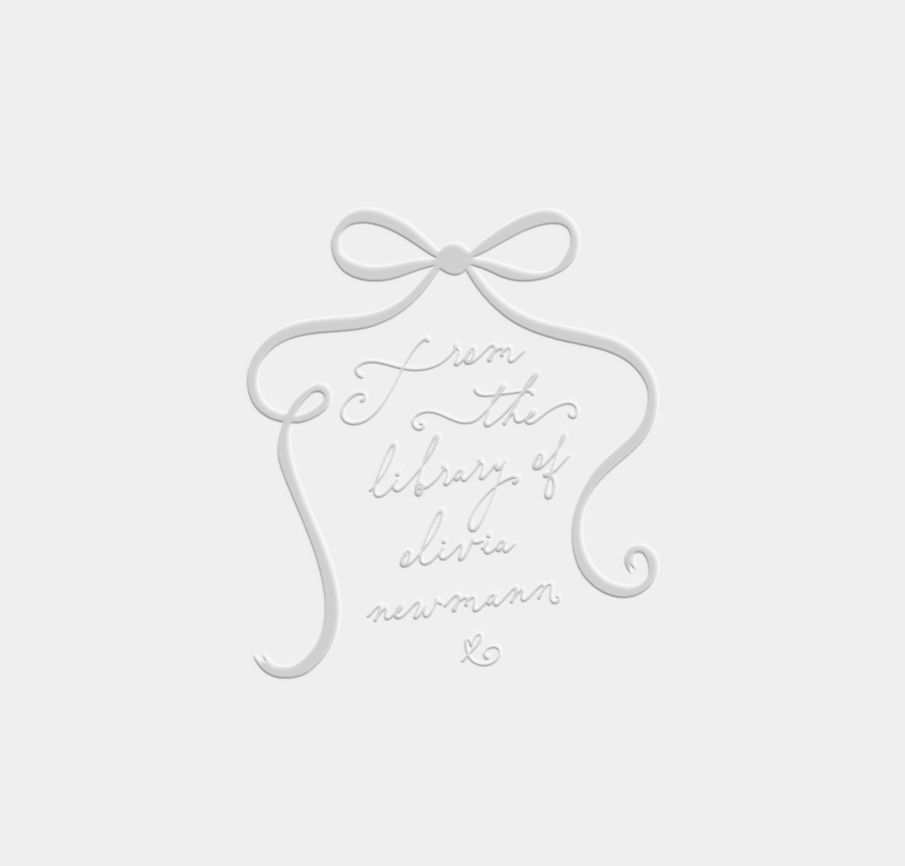 Decorative bow with text 'from the library of' on a light gray background used for a book embosser