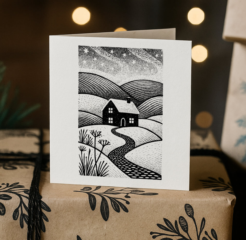 Greeting card with a black and white landscape illustration on a wrapped gift box.