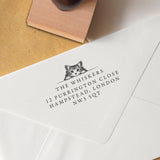 This Cat Address Stamp features a detailed black-and-white illustration of a cat peeking over a wall and personalised address details stamped onto an envelope.