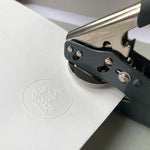 Custom Logo Embosser leaving a raised impression onto plain white paper