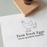 textured paper with the wording 'Farm Fresh Eggs' and chicken illustration stamped on white textured paper
