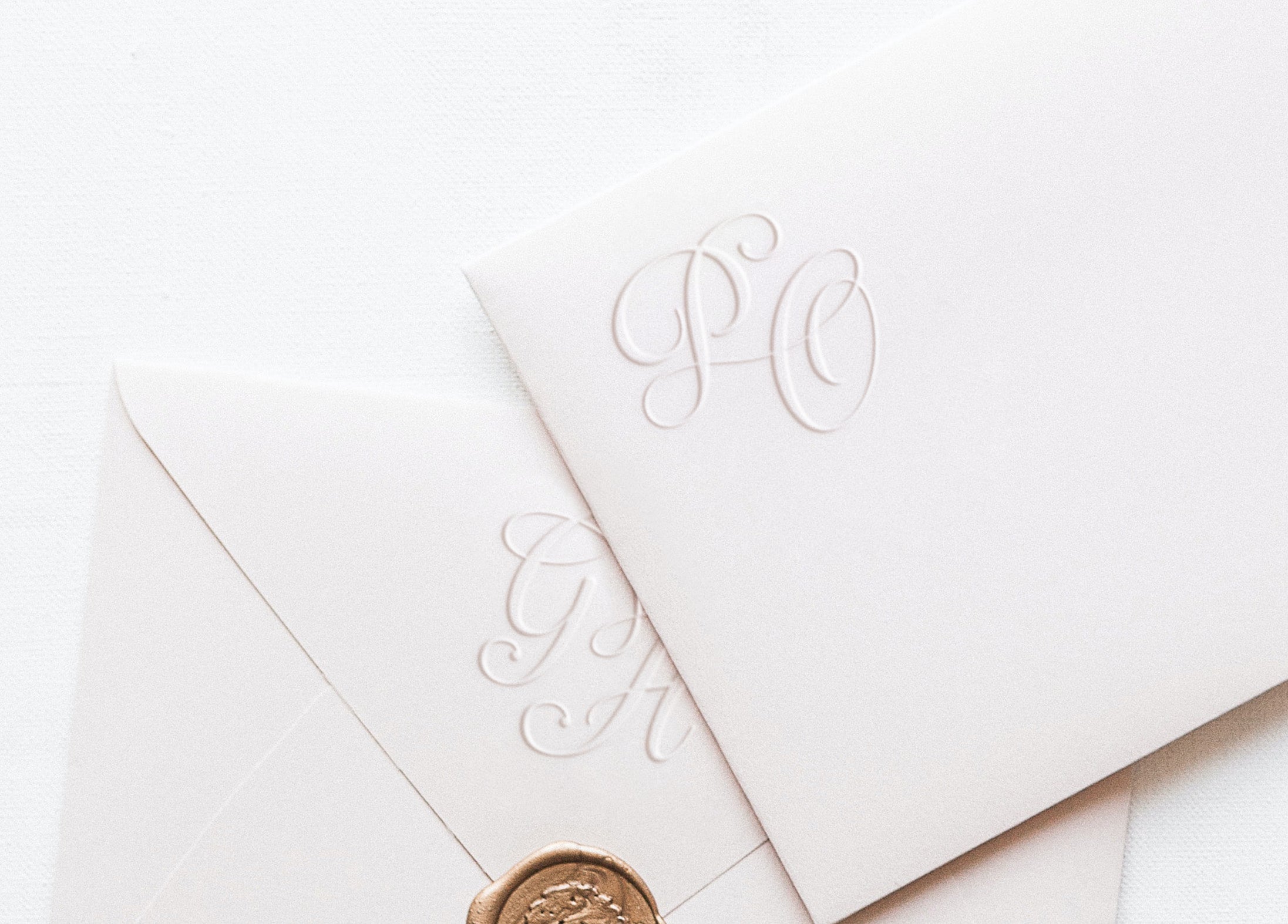 White envelopes with monogram embossed for wedding