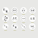 A collection of custom monogram stamps with various initial letters, designed for use on wedding invitations and favors.