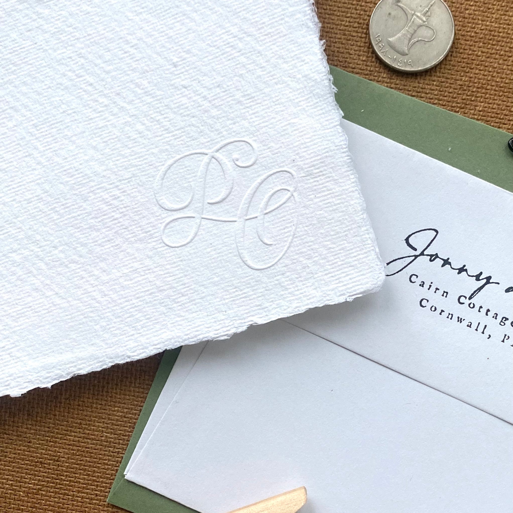 Close-up of wedding stationery with embossed initials.