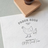 Rubber stamp with the wording fresh eggs and a beautiful illustration of two chickens, and your custom wording onto white textured paper 