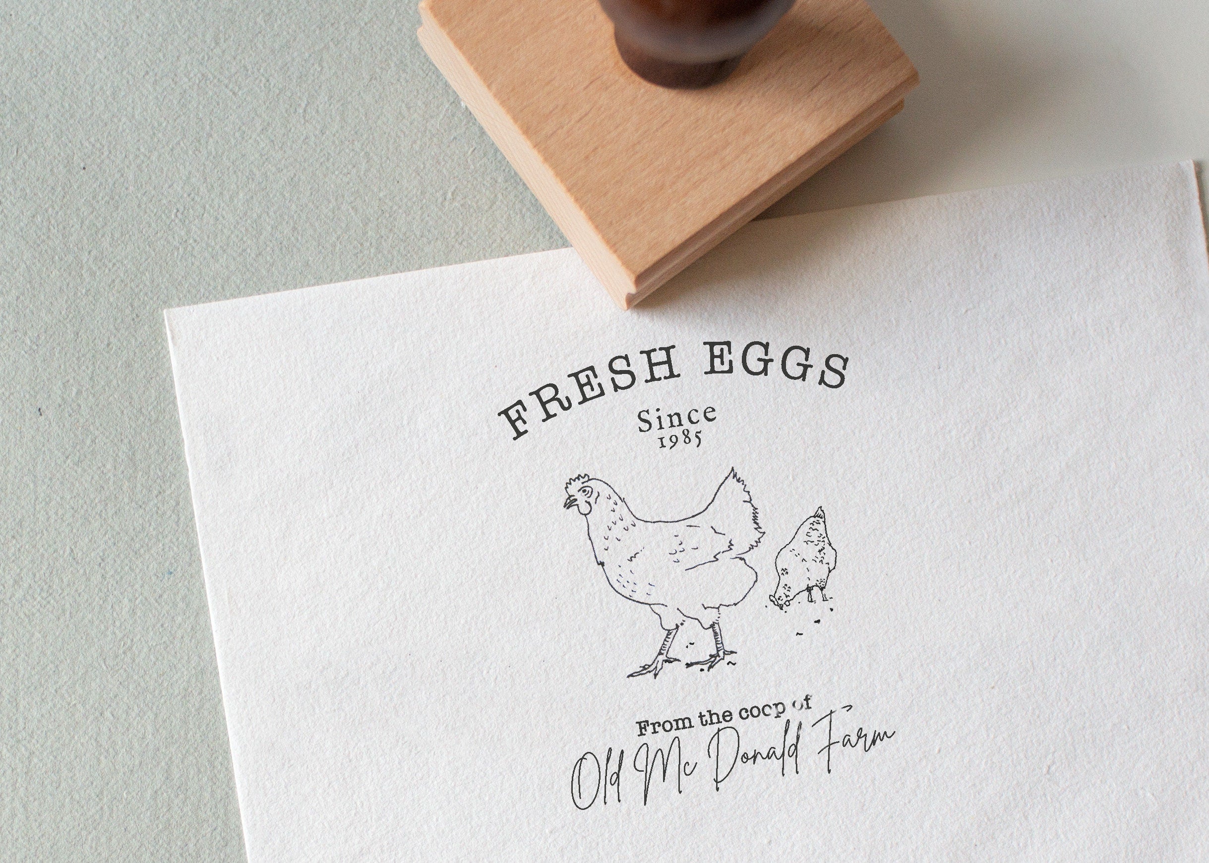 Rubber stamp with the wording fresh eggs and a beautiful illustration of two chickens, and your custom wording onto white textured paper 