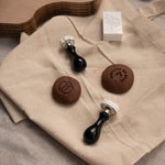 Two custom pottery stamps or makers marks next to two pieces of clay with clay logo impressions 