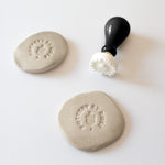 Example of a logo imprint on clay made with a custom pottery stamp or makers mark