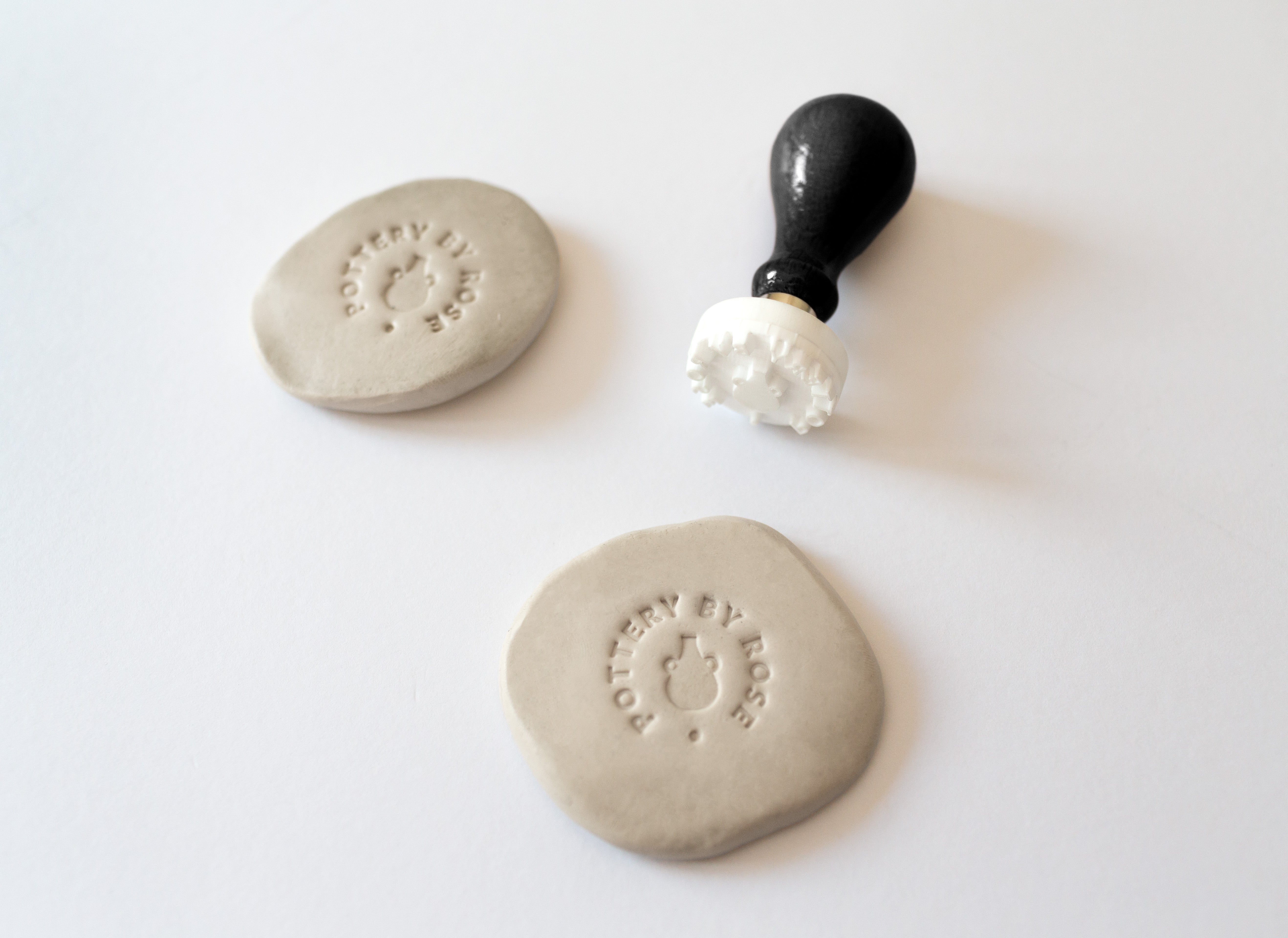 Example of a logo imprint on clay made with a custom pottery stamp or makers mark