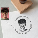 custom rubber portrait stamp with a stamped portrait illustration and 'the wording Approved by Jonathan Newman'  on a paper surface.