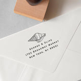 custom beach address stamp featuring a seashell design, personalised address details stamped on to an envelope