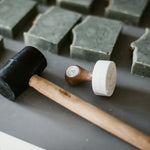 custom soap stamp from About You stationery laying next to soap bars with impressed logos 