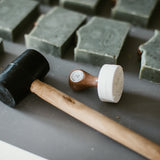 custom soap stamp from About You stationery laying next to soap bars with impressed logos 