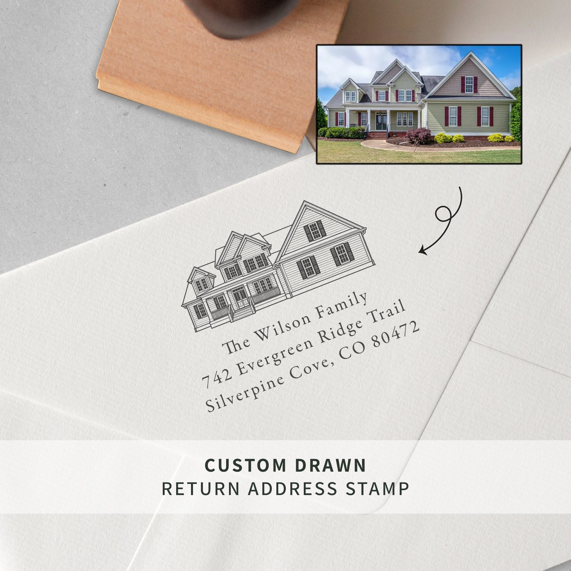 A custom drawn return address stamp shown on a white envelope, featuring a line drawing of a house and the printed name/address 'The Wilson Family 742 Evergreen Ridge Trail Silverpine Cove, CO 80472.' A small inset photo of a house appears in the top right, and text at the bottom reads 'CUSTOM DRAWN RETURN ADDRESS STAMP.