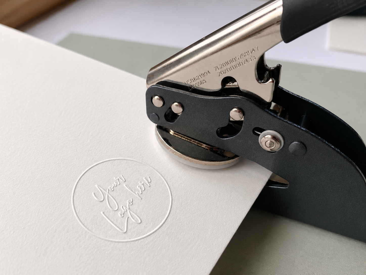 Handheld embosser seal creating a custom logo impression on white card