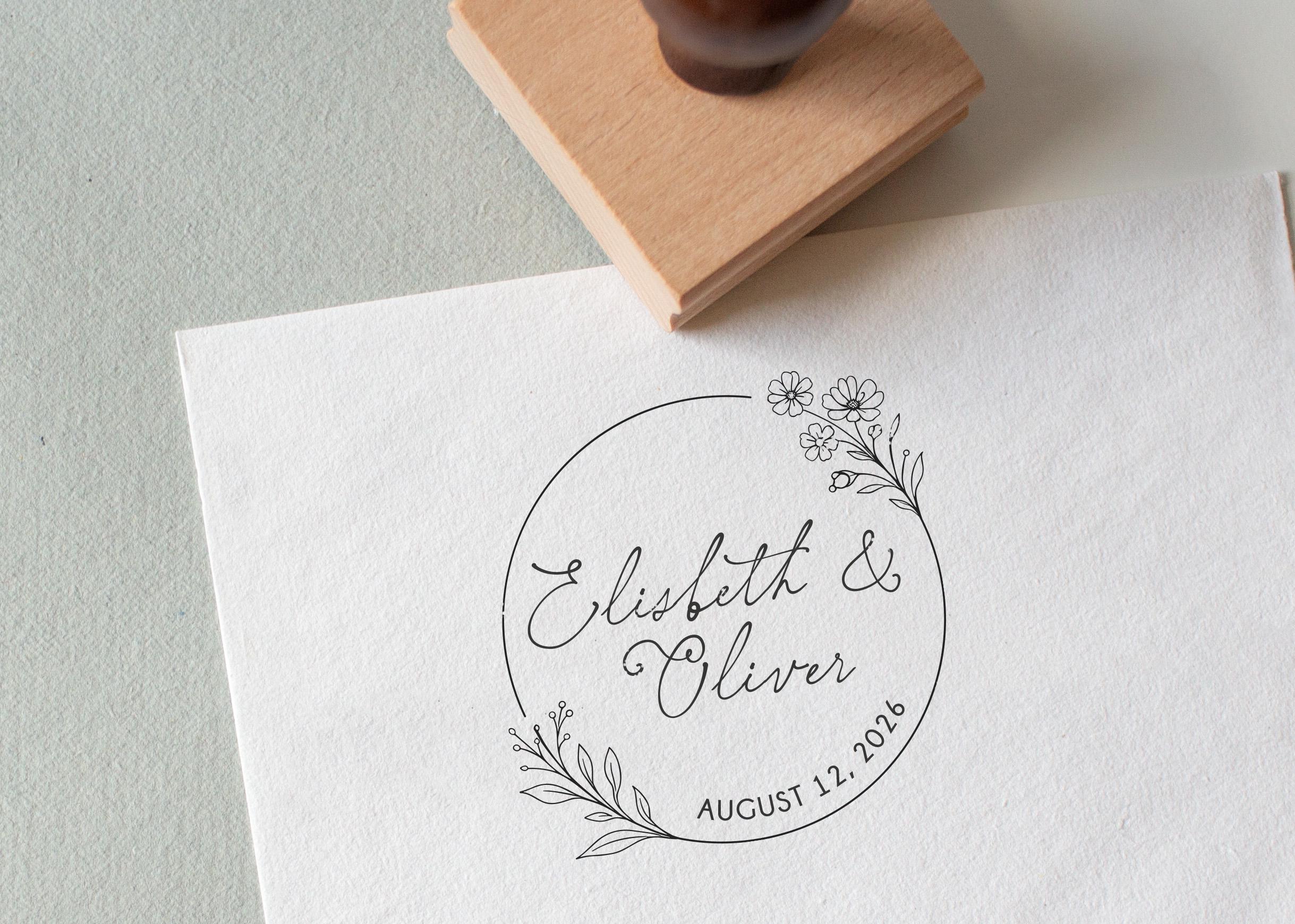 Personalized wedding stamp with names and date, and a beautiful floral wreath stamped onto a wedding card