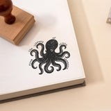 Book stamp with a beautiful octopus illustration and the wording 'from the library of' stamped onto a book page