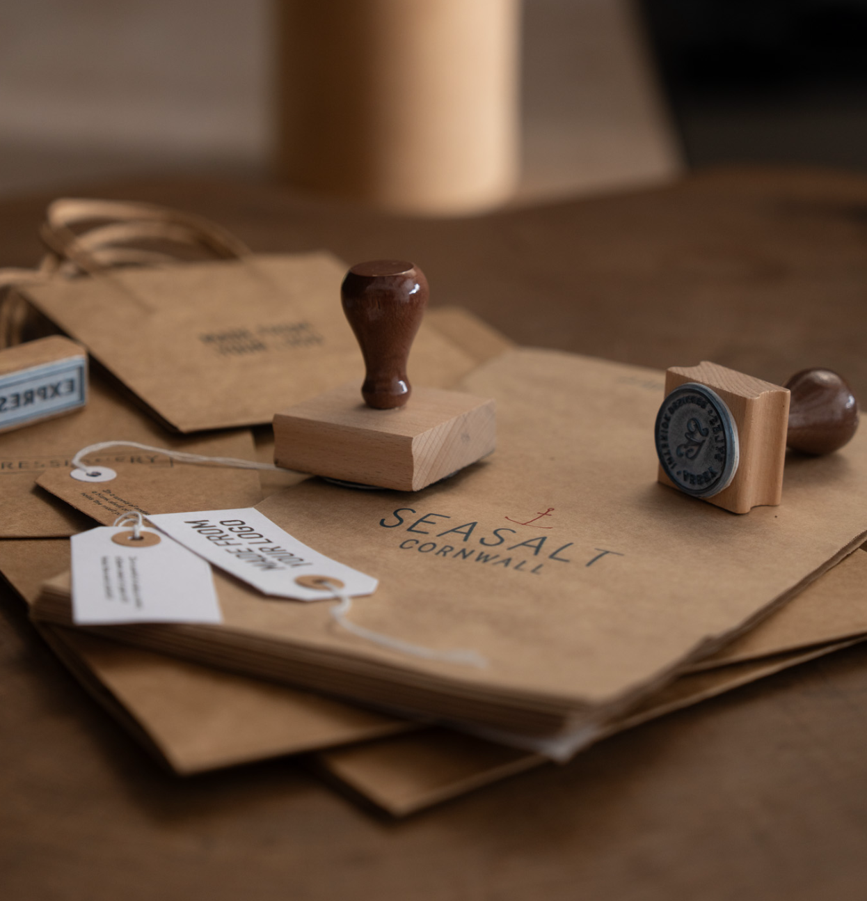 Wooden stamp with custom wording stamped onto a brown paper bag