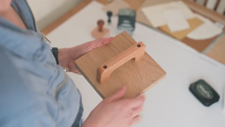 Custom Large Rubber Logo Stamp stamping the 'about you stationery' logo onto a big sheet of white paper 