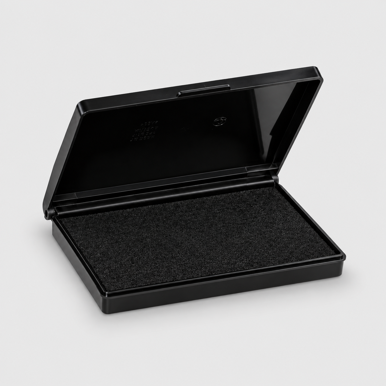 A black rectangular ink pad case shown open, revealing a textured black ink pad inside, set against a light gray background.