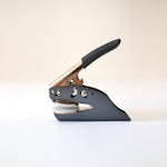 Black and silver, steel embosser on a white background