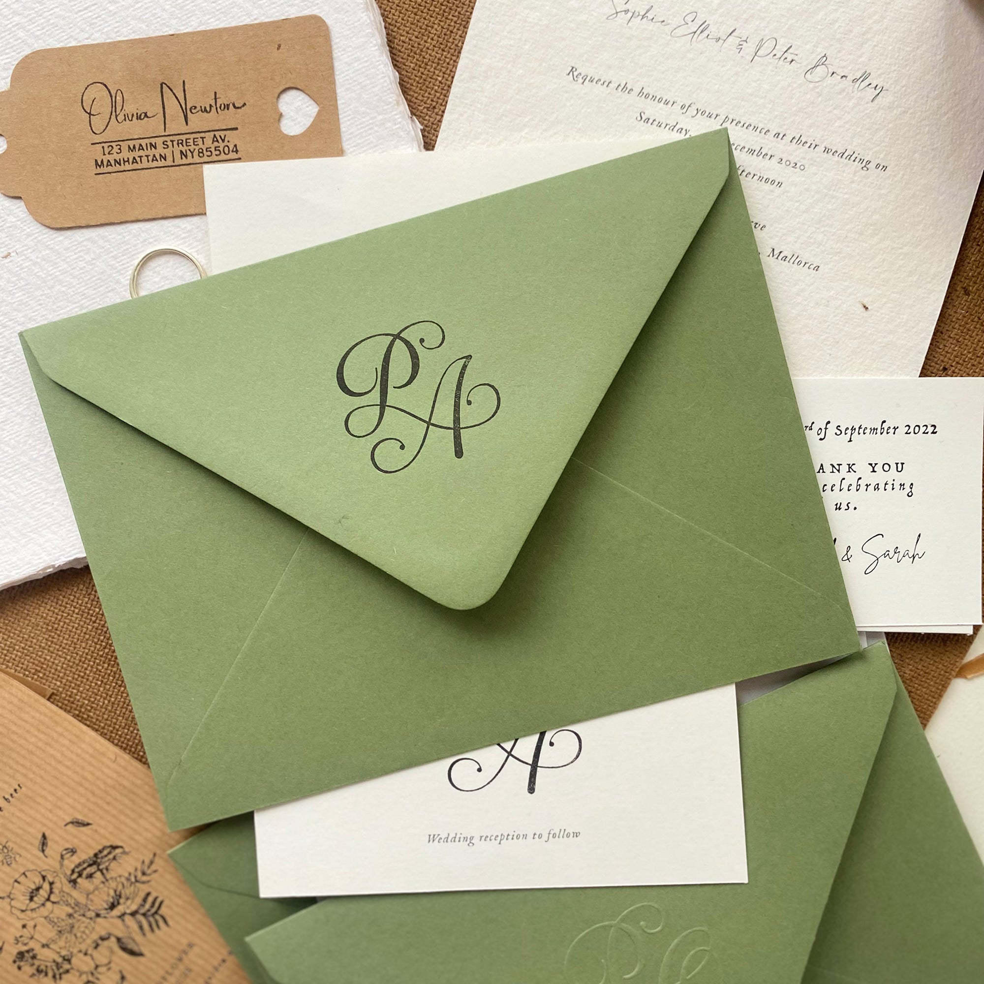 Calligraphy Monogram design stamped on a textured green envelope 