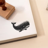 Custom book stamp with whale illustration stamped on a book page with the wording 'from the library of'.