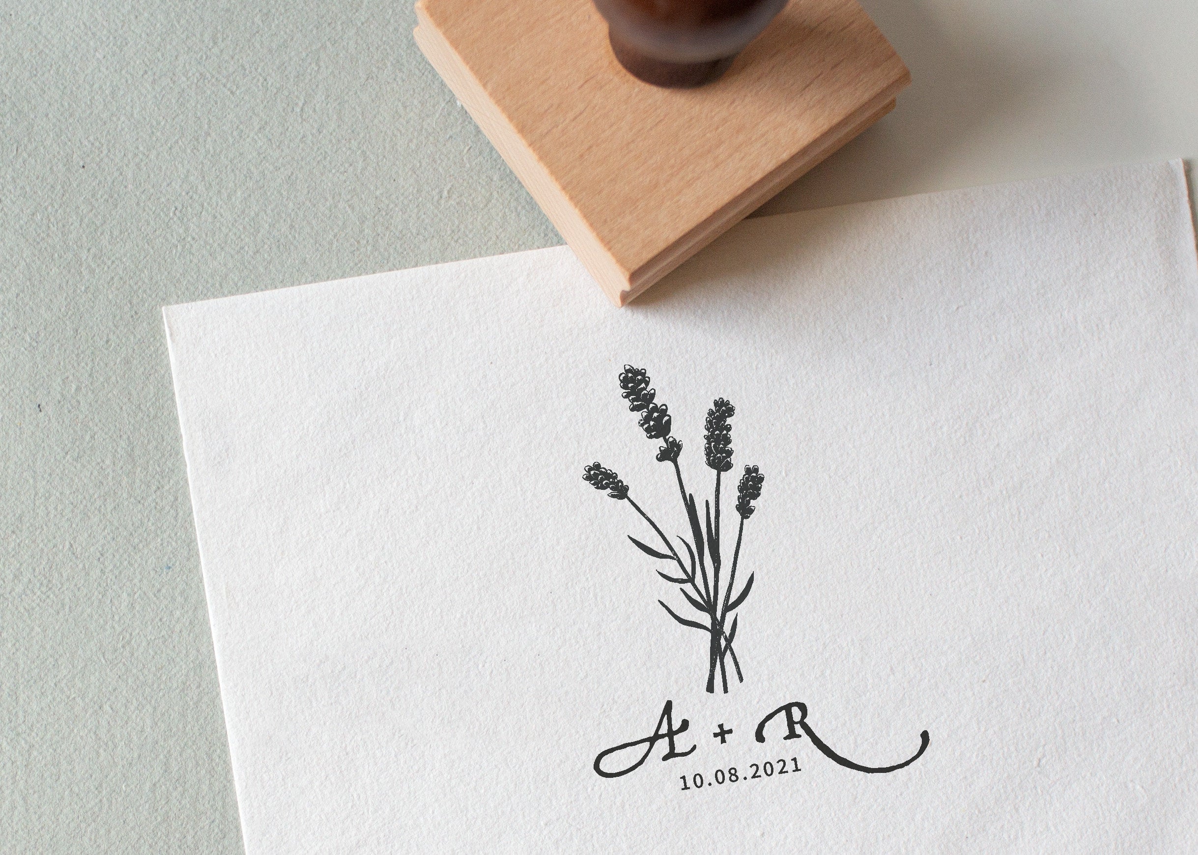 Lavender wedding stamp with couple’s initials and date, stamped on white textured paper