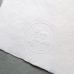 Logo embossed with Long Reach Embosser on paper.