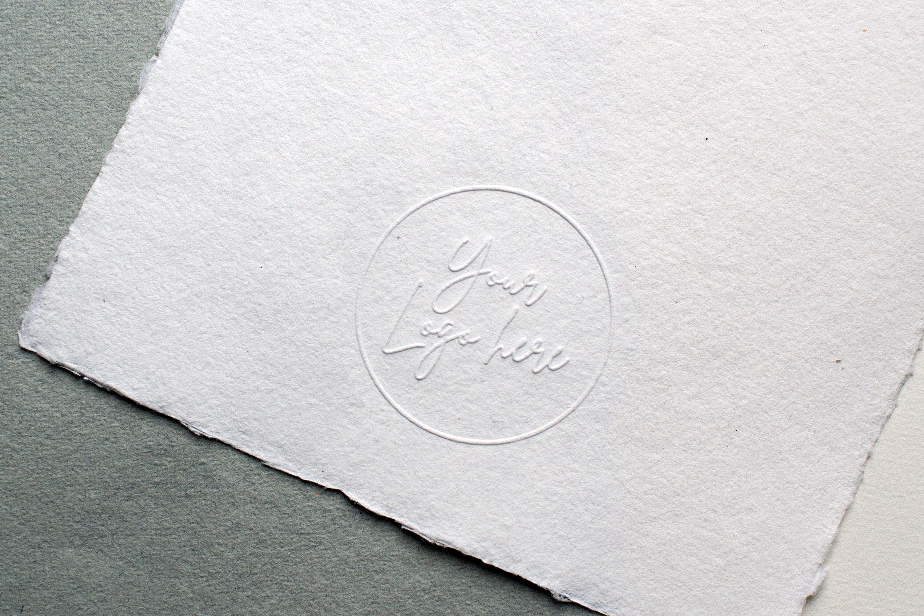 Logo embossed with Long Reach Embosser on paper.
