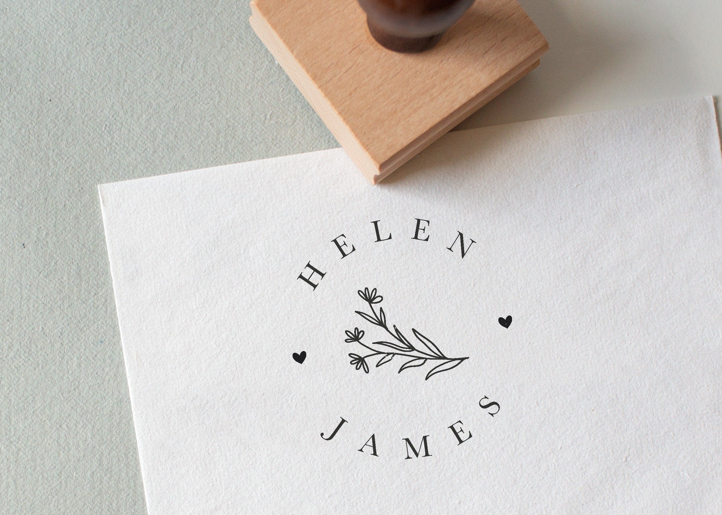 Daisy's wedding stamp with the couple’s names in a circular layout, stamped on white textured paper