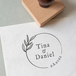 Minimal circle wedding stamp with couple’s names and date, and a beautiful botanical illustration stamped on white textured paper