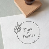 Minimal circle wedding stamp with couple’s names and date, and a beautiful botanical illustration stamped on white textured paper