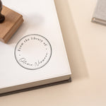 Minimal Script Book Stamp featuring a minimal design of a book stamp with a beautiful script and handwritten font stamped onto the pages of a book